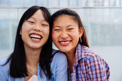 Happy beautiful chinese women friends bonding outdoors in the city - Playful pretty asian female adults meeting and having fun outside, concepts about lifestyle and friendship - DMDF08006