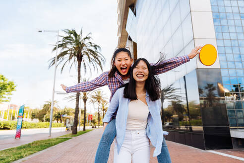 Happy beautiful chinese women friends bonding outdoors in the city - Playful pretty asian female adults meeting and having fun outside, concepts about lifestyle and friendship - DMDF08014