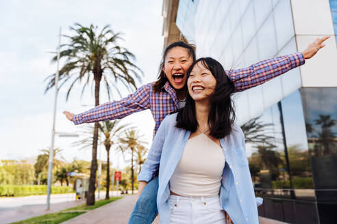 Happy beautiful chinese women friends bonding outdoors in the city - Playful pretty asian female adults meeting and having fun outside, concepts about lifestyle and friendship - DMDF08015