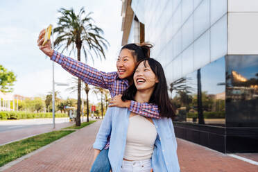 Glücklich schöne chinesische Frauen Freunde Bindung im Freien in der Stadt - Playful hübsche asiatische weibliche Erwachsene treffen und Spaß haben draußen, Konzepte über Lifestyle und Freundschaft - DMDF08017