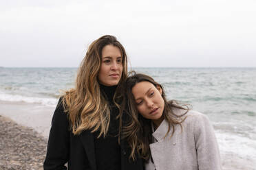 Woman leaning on girlfriend's shoulder at beach - MMPF01104