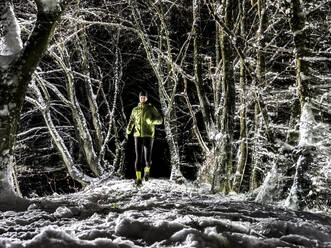 Mann läuft auf Schnee im Winterwald - STSF03806