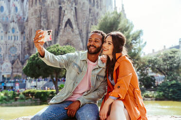 Multirassisches glückliches Liebespaar an der Sagrada Familia, Barcelona - Multiethnische Touristen, die in Europa reisen und eine Stadt in Spanien besuchen, Konzepte über Tourismus und Lebensstil der Menschen - DMDF08155