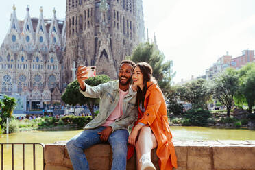 Multirassisches glückliches Liebespaar an der Sagrada Familia, Barcelona - Multiethnische Touristen, die in Europa reisen und eine Stadt in Spanien besuchen, Konzepte über Tourismus und Lebensstil der Menschen - DMDF08156