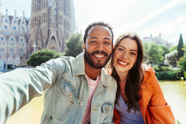 Multirassisches glückliches Liebespaar an der Sagrada Familia, Barcelona - Multiethnische Touristen, die in Europa reisen und eine Stadt in Spanien besuchen, Konzepte über Tourismus und Lebensstil der Menschen - DMDF08160