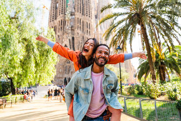 Multirassisches glückliches Liebespaar an der Sagrada Familia, Barcelona - Multiethnische Touristen, die in Europa reisen und eine Stadt in Spanien besuchen, Konzepte über Tourismus und Lebensstil der Menschen - DMDF08185