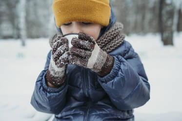 Junge mit Strickmütze und Teetrinken im Winter - ANAF02613