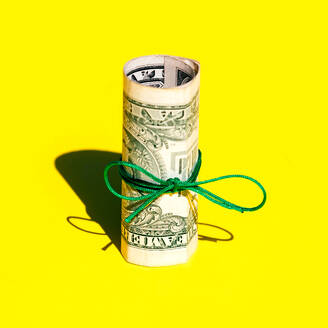 Nahaufnahme von gerollten einen Dollar Papier Währung gebunden auf gelbem Hintergrund mit Kopie Raum - ADSF50861