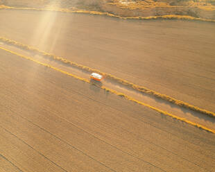 Aerial view of a vintage orange campervan, in the Bardenas Reales Desert at sunrise, Navarra, Spain. - AAEF24828