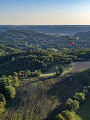 Luftaufnahme eines Heißluftballons, der über den Wald und die Landschaft in der Nähe des Dorfes La Roque-Gageac fliegt, Nouvelle-Aquitaine, Südwestfrankreich - AAEF25039
