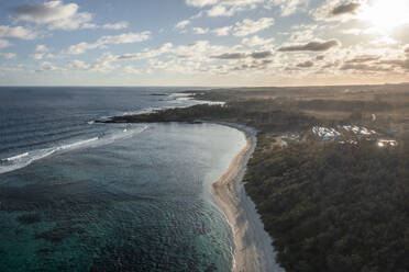 Luftaufnahme des Strandes Le Cambuse mit weißem Sand entlang der Küstenlinie bei Sonnenuntergang, Grand Port, Mauritius. - AAEF25093