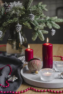 Christmas candles decoration placed on table near tree - ALKF00911