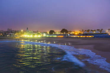 Portugal, Lisbon District, Estoril, Tamariz Beach at dusk with lights in background - ABOF00941