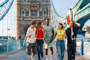 Multirassische Gruppe von glücklichen jungen Freunden in der Londoner City - Multiethnische Teenager treffen sich und haben Spaß in der Tower Bridge, UK - Konzepte über jugendlichen Lebensstil, Reisen und Tourismus - DMDF08714