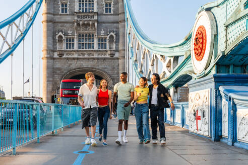 Multirassische Gruppe von glücklichen jungen Freunden in der Londoner City - Multiethnische Teenager treffen sich und haben Spaß in der Tower Bridge, UK - Konzepte über jugendlichen Lebensstil, Reisen und Tourismus - DMDF08716