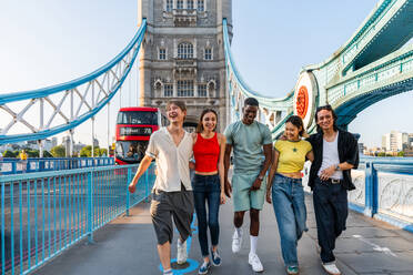 Multirassische Gruppe von glücklichen jungen Freunden in der Londoner City - Multiethnische Teenager treffen sich und haben Spaß in der Tower Bridge, UK - Konzepte über jugendlichen Lebensstil, Reisen und Tourismus - DMDF08717