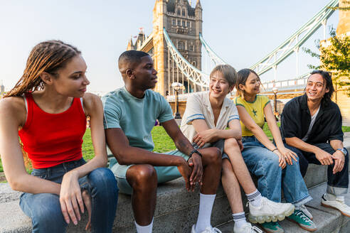 Multirassische Gruppe von glücklichen jungen Freunden in der Londoner City - Multiethnische Teenager treffen sich und haben Spaß in der Tower Bridge, UK - Konzepte über jugendlichen Lebensstil, Reisen und Tourismus - DMDF08728