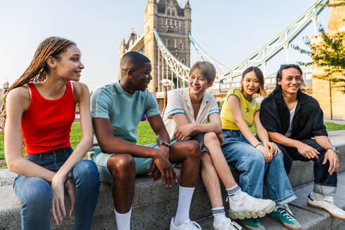 Multirassische Gruppe von glücklichen jungen Freunden in der Londoner City - Multiethnische Teenager treffen sich und haben Spaß in der Tower Bridge, UK - Konzepte über jugendlichen Lebensstil, Reisen und Tourismus - DMDF08729