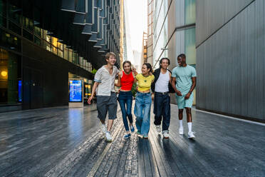 Multirassische Gruppe von glücklichen jungen Freunden in der Londoner City - Multiethnische Teenager treffen sich und haben Spaß in der Tower Bridge, UK - Konzepte über jugendlichen Lebensstil, Reisen und Tourismus - DMDF08738
