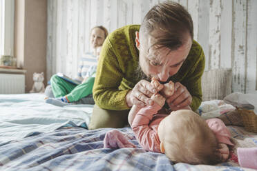 Vater spielt mit Tochter auf Bett zu Hause - IHF01858