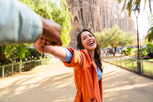 Multiracial beautiful happy couple of lovers dating at Sagrada Familia, Barcelona - Multiethnic tourists travelling in Europe and visiting a city in Spain, concepts about tourism and people lifestyle - DMDF08752