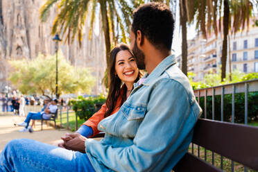 Multiracial beautiful happy couple of lovers dating at Sagrada Familia, Barcelona - Multiethnic tourists travelling in Europe and visiting a city in Spain, concepts about tourism and people lifestyle - DMDF08761