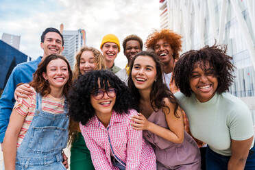 Happy playful multiethnic group of young friends bonding outdoors - Multiracial millennials students meeting in the city, concepts of youth, people lifestyle, diversity, teenage and urban life - DMDF08828