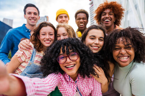 Happy playful multiethnic group of young friends bonding outdoors - Multiracial millennials students meeting in the city, concepts of youth, people lifestyle, diversity, teenage and urban life - DMDF08830