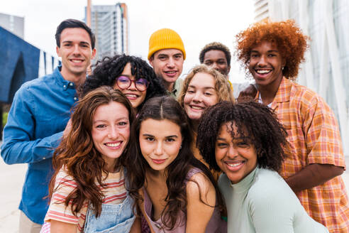 Happy playful multiethnic group of young friends bonding outdoors - Multiracial millennials students meeting in the city, concepts of youth, people lifestyle, diversity, teenage and urban life - DMDF08833