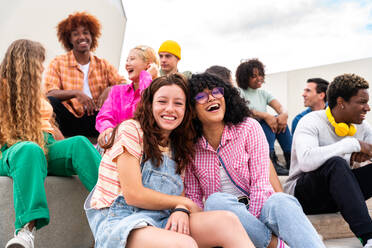 Happy playful multiethnic group of young friends bonding outdoors - Multiracial millennials students meeting in the city, concepts of youth, people lifestyle, diversity, teenage and urban life - DMDF08834