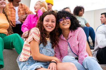 Happy playful multiethnic group of young friends bonding outdoors - Multiracial millennials students meeting in the city, concepts of youth, people lifestyle, diversity, teenage and urban life - DMDF08835