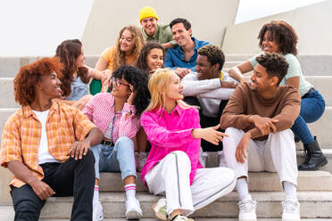 Happy playful multiethnic group of young friends bonding outdoors - Multiracial millennials students meeting in the city, concepts of youth, people lifestyle, diversity, teenage and urban life - DMDF08846