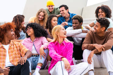 Happy playful multiethnic group of young friends bonding outdoors - Multiracial millennials students meeting in the city, concepts of youth, people lifestyle, diversity, teenage and urban life - DMDF08847