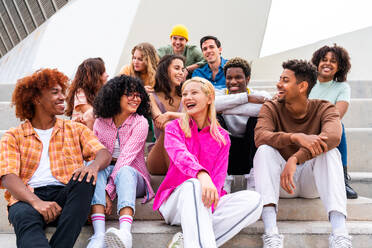 Happy playful multiethnic group of young friends bonding outdoors - Multiracial millennials students meeting in the city, concepts of youth, people lifestyle, diversity, teenage and urban life - DMDF08851