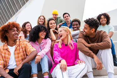 Happy playful multiethnic group of young friends bonding outdoors - Multiracial millennials students meeting in the city, concepts of youth, people lifestyle, diversity, teenage and urban life - DMDF08854