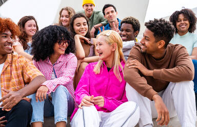 Happy playful multiethnic group of young friends bonding outdoors - Multiracial millennials students meeting in the city, concepts of youth, people lifestyle, diversity, teenage and urban life - DMDF08856