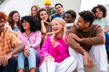 Happy playful multiethnic group of young friends bonding outdoors - Multiracial millennials students meeting in the city, concepts of youth, people lifestyle, diversity, teenage and urban life - DMDF08857