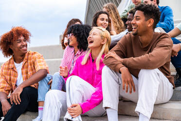 Happy playful multiethnic group of young friends bonding outdoors - Multiracial millennials students meeting in the city, concepts of youth, people lifestyle, diversity, teenage and urban life - DMDF08861