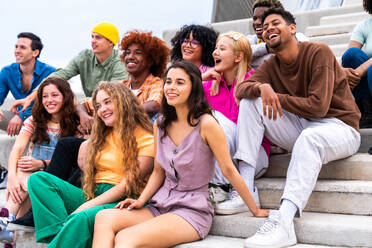 Happy playful multiethnic group of young friends bonding outdoors - Multiracial millennials students meeting in the city, concepts of youth, people lifestyle, diversity, teenage and urban life - DMDF08876