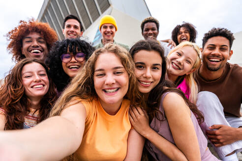 Happy playful multiethnic group of young friends bonding outdoors - Multiracial millennials students meeting in the city, concepts of youth, people lifestyle, diversity, teenage and urban life - DMDF08880