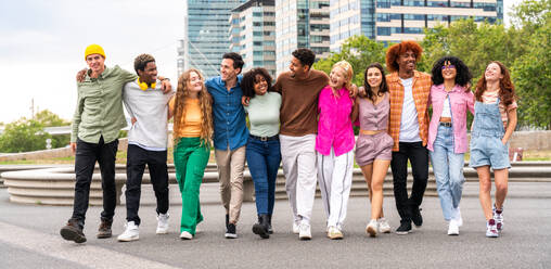 Fröhliche, verspielte, multiethnische Gruppe junger Freunde, die sich im Freien treffen - Multirassische Millennial-Studenten, die sich in der Stadt treffen, Konzepte von Jugend, Lebensstil, Vielfalt, Teenager- und Stadtleben - DMDF08964