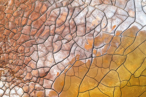 A close-up aerial view of the cracked earth in Riotinto, capturing the abstract beauty and rich earthy tones of the terrain's natural patterns. - ADSF50952