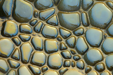 Close-up of eroded shapes glistening with water and reflecting the golden light of the sun. - ADSF51047