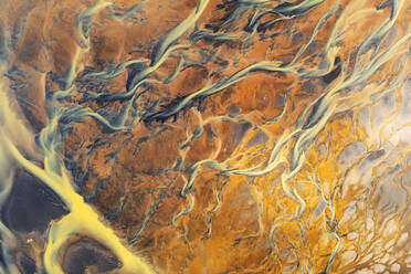 Aerial view capturing the intricate patterns of Icelandic river basins with vivid hues and dynamic waterways - ADSF51052