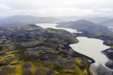 Aerial view of Iceland's rugged landscapes featuring winding river basins amidst the golden hues of the terrain - ADSF51089