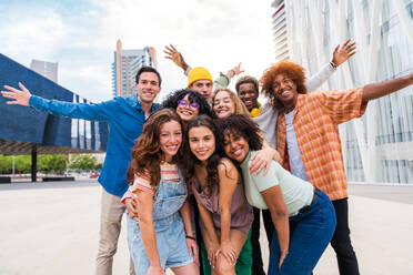 Happy playful multiethnic group of young friends bonding outdoors - Multiracial millennials students meeting in the city, concepts of youth, people lifestyle, diversity, teenage and urban life - DMDF08977