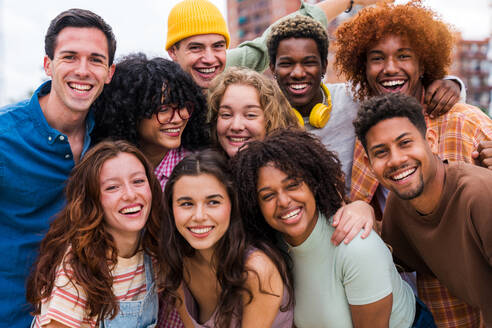 Happy playful multiethnic group of young friends bonding outdoors - Multiracial millennials students meeting in the city, concepts of youth, people lifestyle, diversity, teenage and urban life - DMDF08982