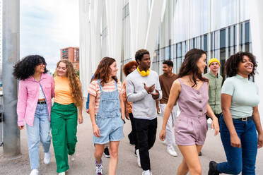 Happy playful multiethnic group of young friends bonding outdoors - Multiracial millennials students meeting in the city, concepts of youth, people lifestyle, diversity, teenage and urban life - DMDF09000