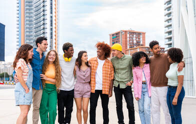 Happy playful multiethnic group of young friends bonding outdoors - Multiracial millennials students meeting in the city, concepts of youth, people lifestyle, diversity, teenage and urban life - DMDF09004