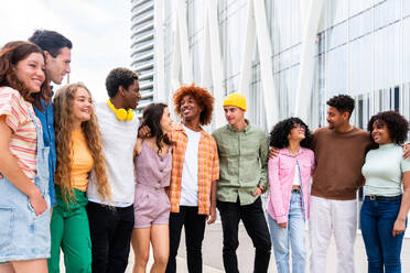 Happy playful multiethnic group of young friends bonding outdoors - Multiracial millennials students meeting in the city, concepts of youth, people lifestyle, diversity, teenage and urban life - DMDF09009